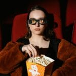 woman eating popcorn in cinema