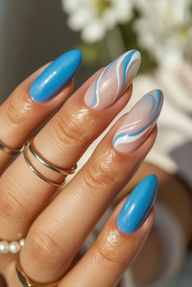 Bright blue nails paired with swirly accent designs give these almond nail designs a fresh, glossy pop. Perfect for those craving vibrant nail ideas that still feel refined.